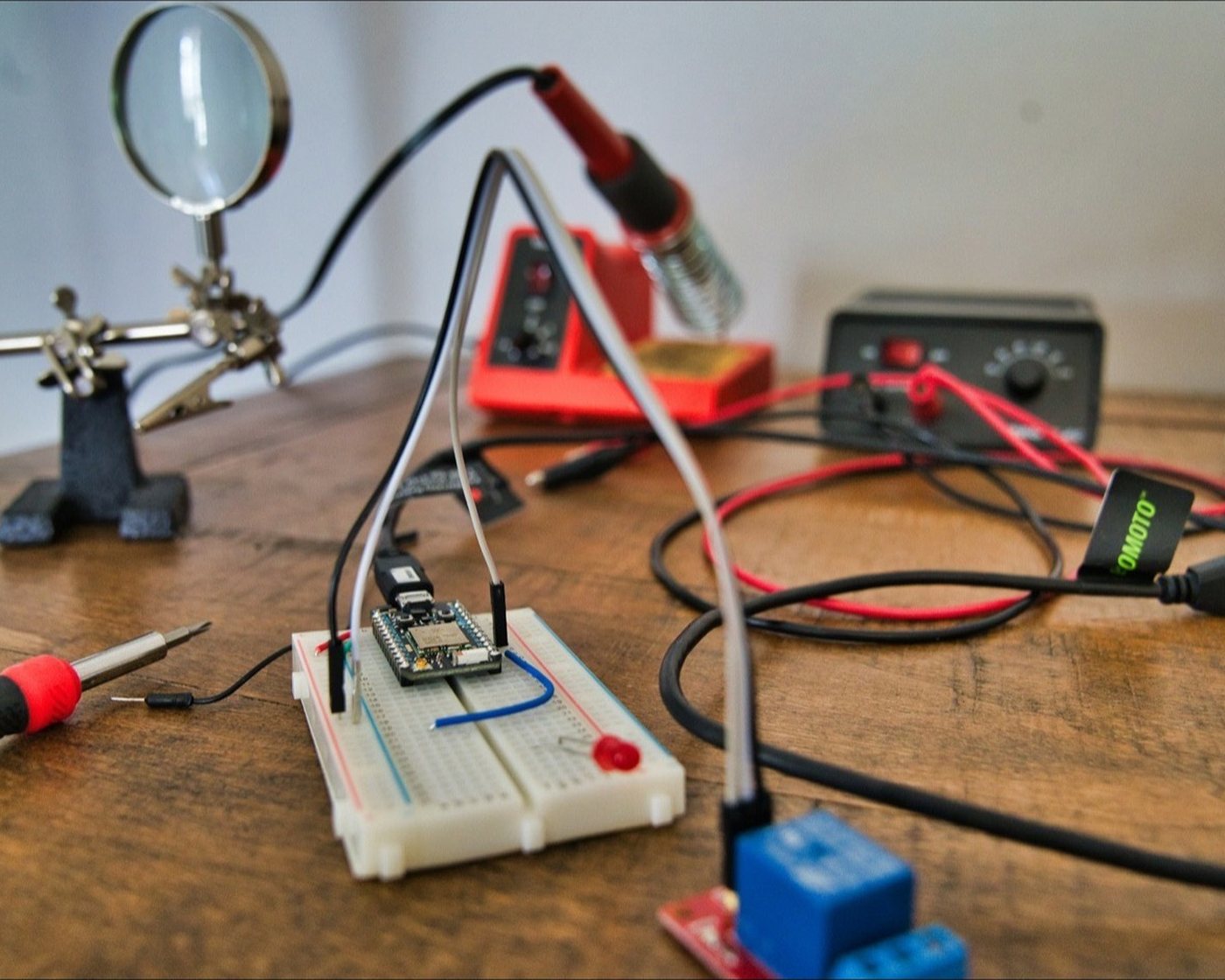 An electronics bench with a multimeter and hand tools